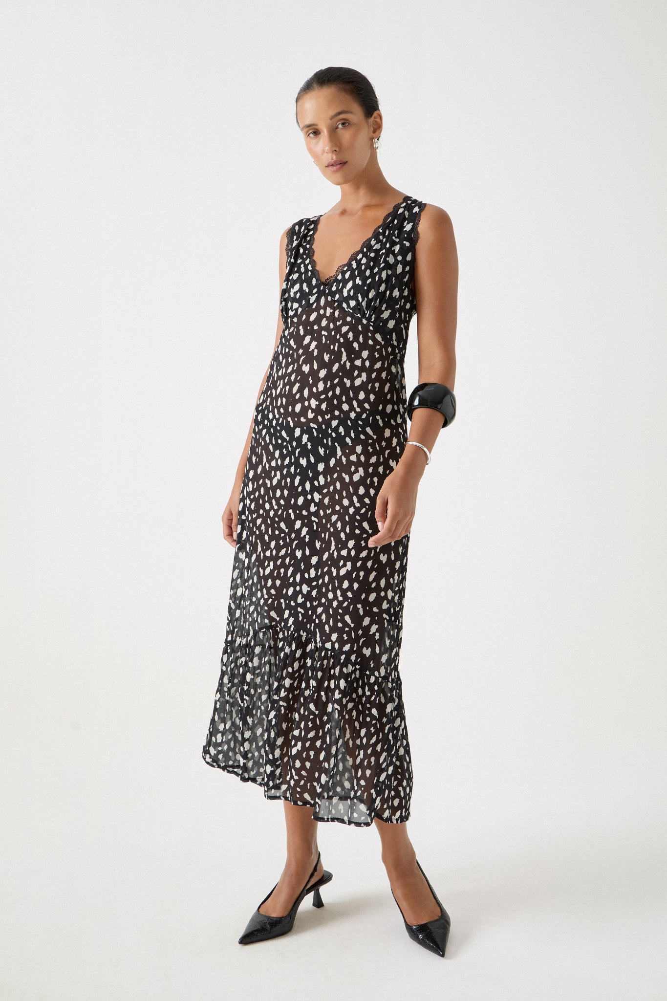 Lightweight dalmatian resort dress shown in motion with scalloped lace hem